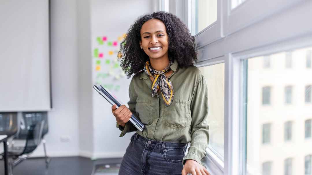 Businesswoman posing and smiling by a window 