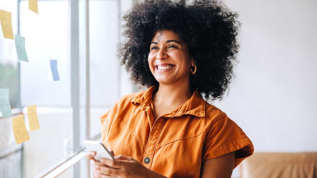 Business woman smiling while looking out a window