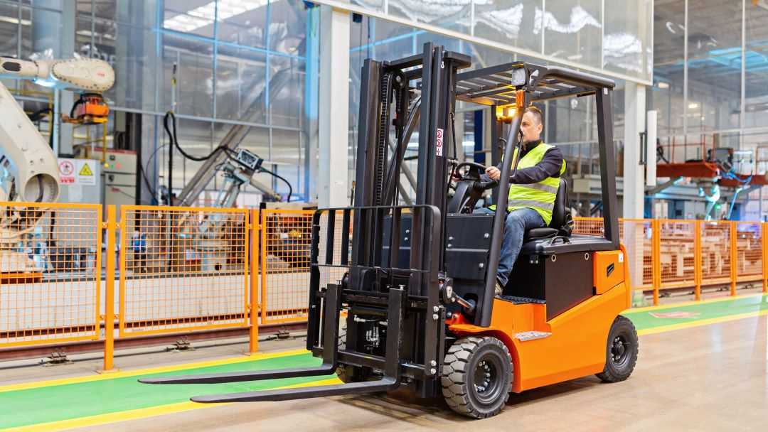 Man in a reflective vest operating a sit down forklift