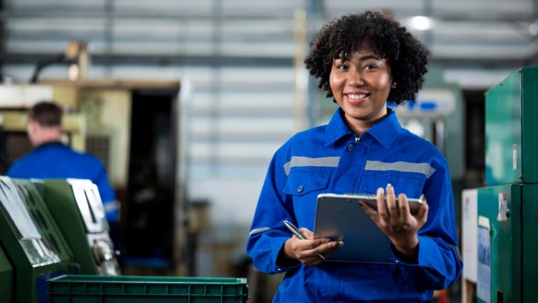 Warehouse worker smiling while holding a clipboard