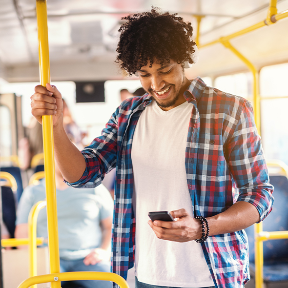 man riding the bus holding a mobile phone