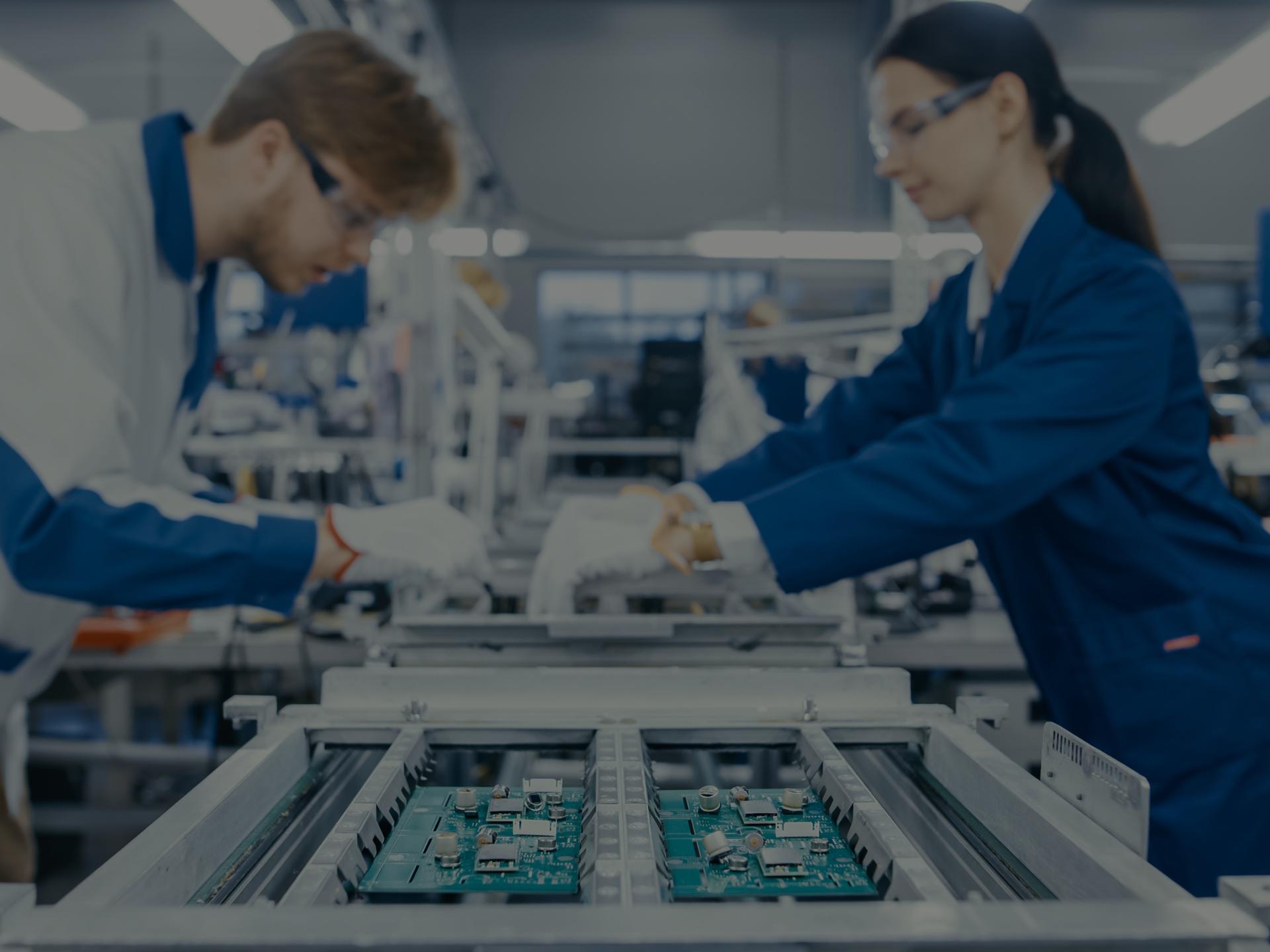 Two workers working on technology hardware. 